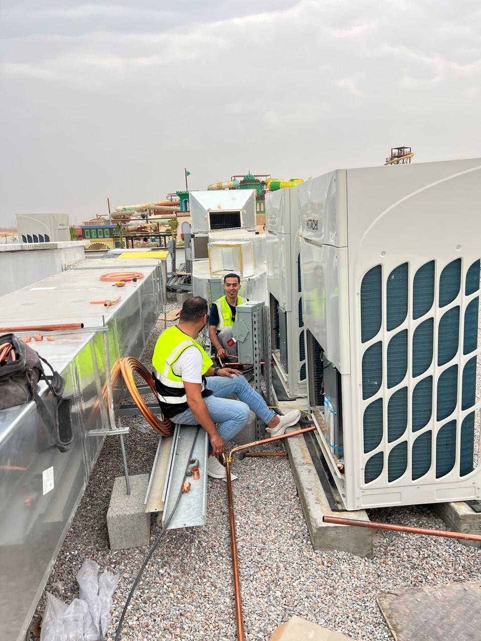 فنيون يعملون على وحدات VRF فوق سطح مبنى